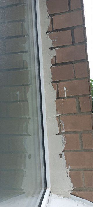 Загерметизированный шов между окном и кирпичной стеной снаружи