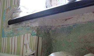 Зона под подоконником до работы: разрушенная штукатурка и пена